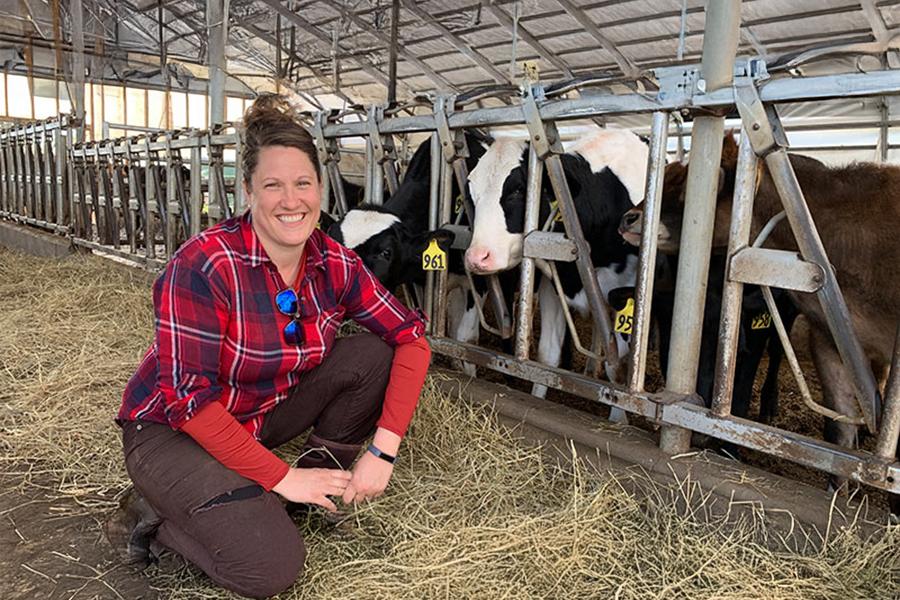 Abbie Corse of Corse Farm Dairy poses with her cows in the barn