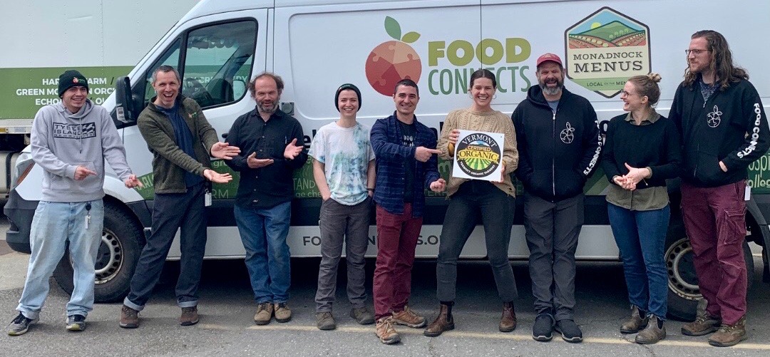 The Food Connects team pictured smiling with their VOF organic certification logo in front of their delivery van
