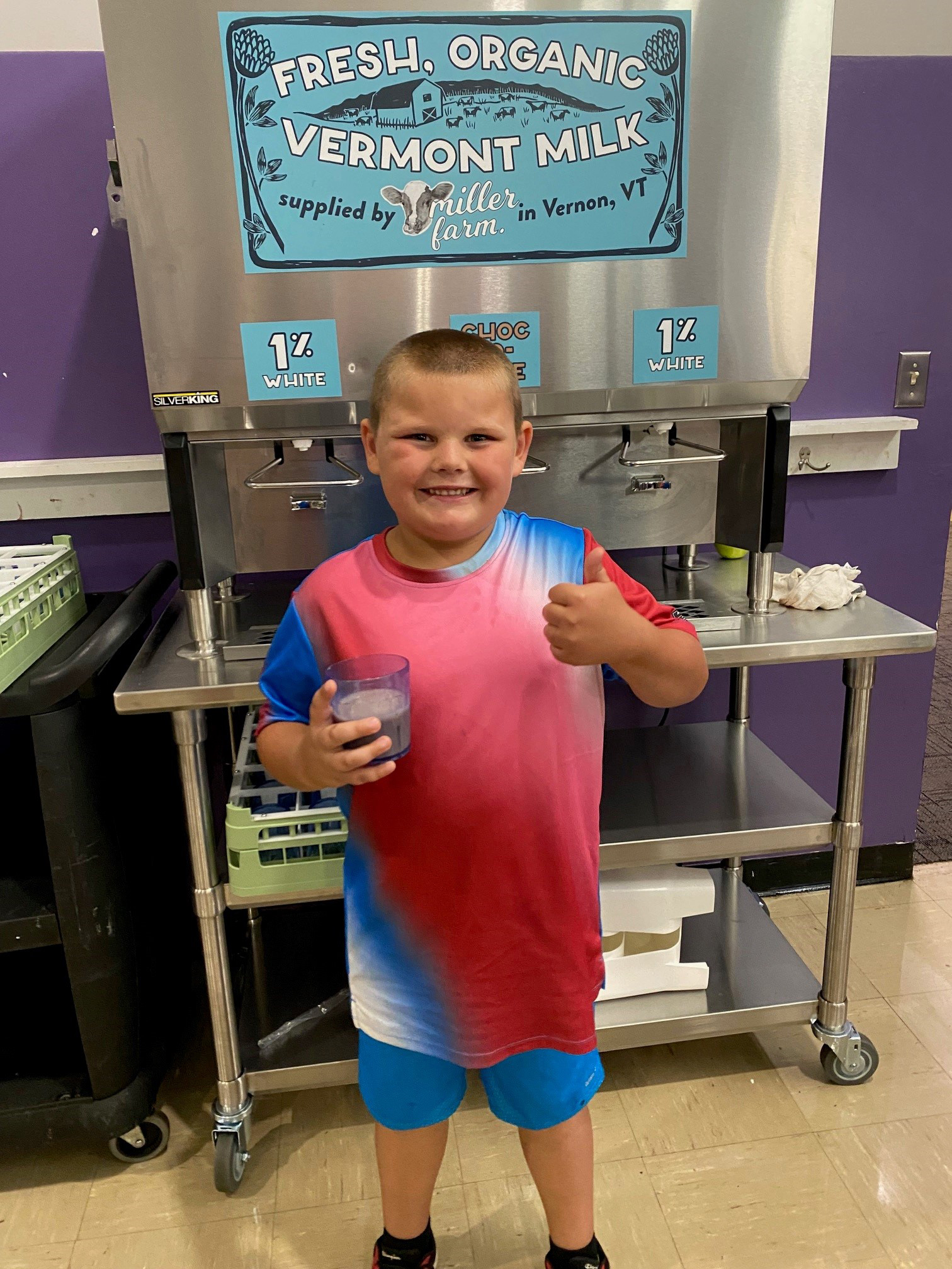 A young student gives an enthusiastic thumbs up to the new Miller Farm local, organic milk dispenser in the school cafeteria