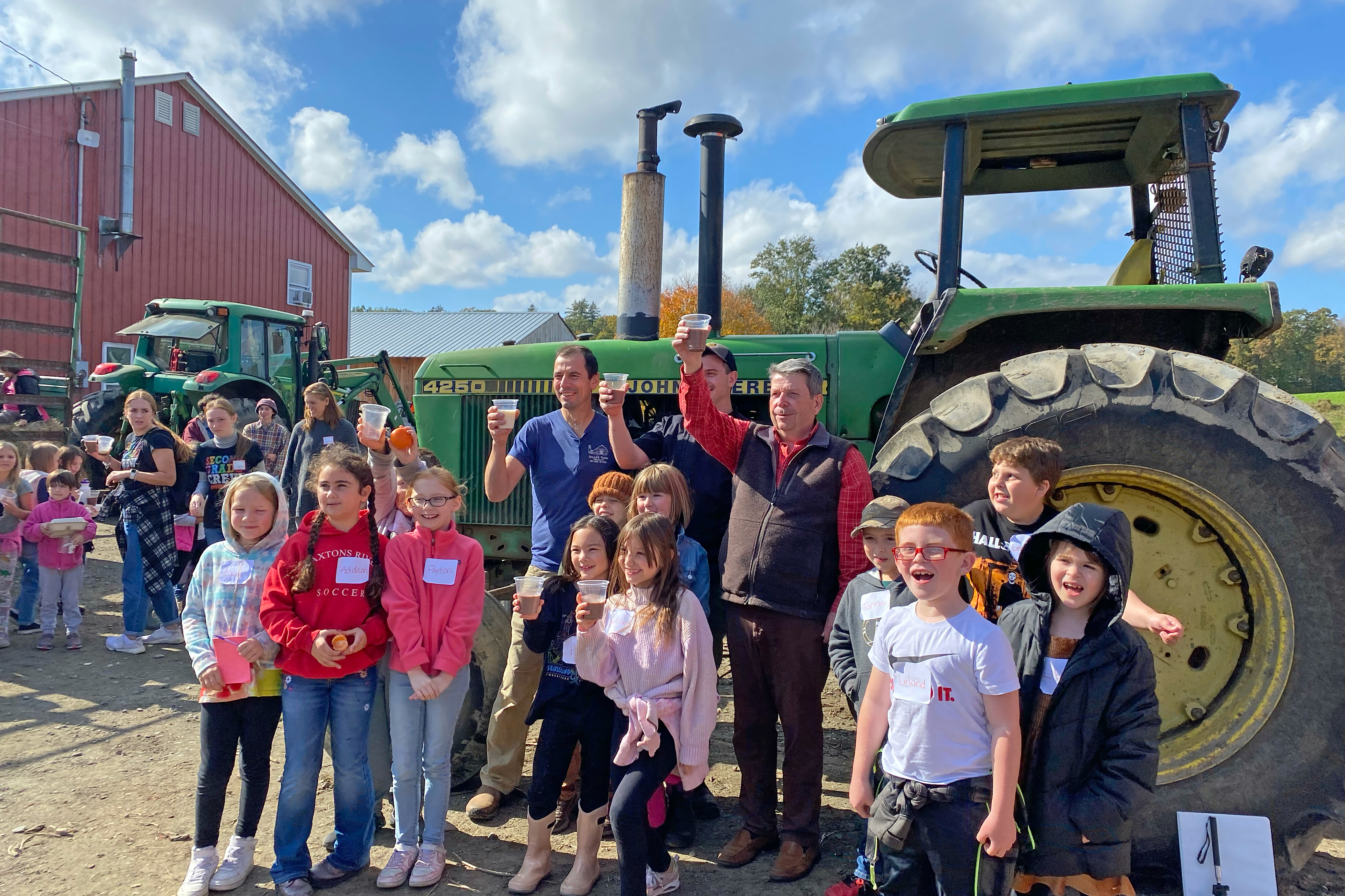 WNESU Students posing with Farmer Peter Miller and his tractor during a field trip to Miller Farm to celebrate the milk pilot project's success