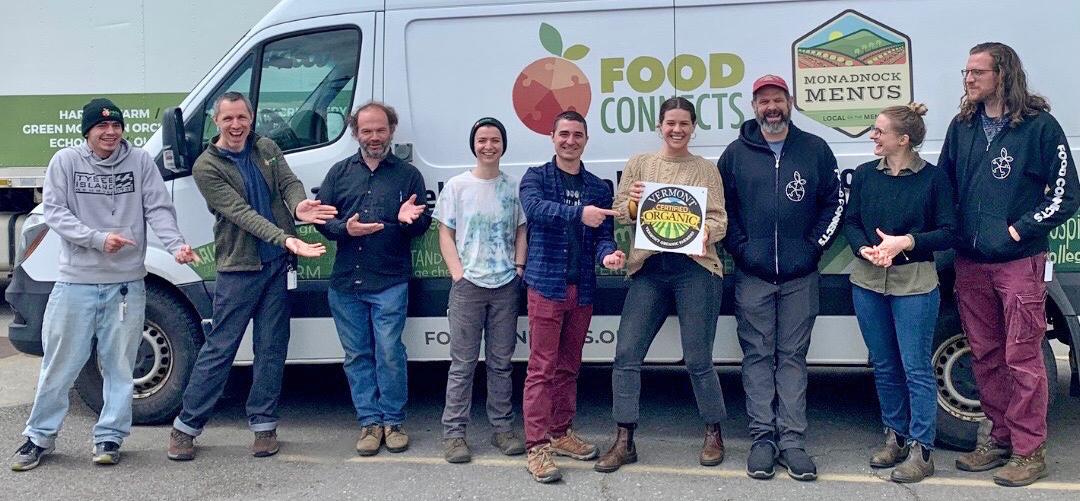 The team at Food Connects poses with their VOF organic certification logo in front of their delivery vehicle