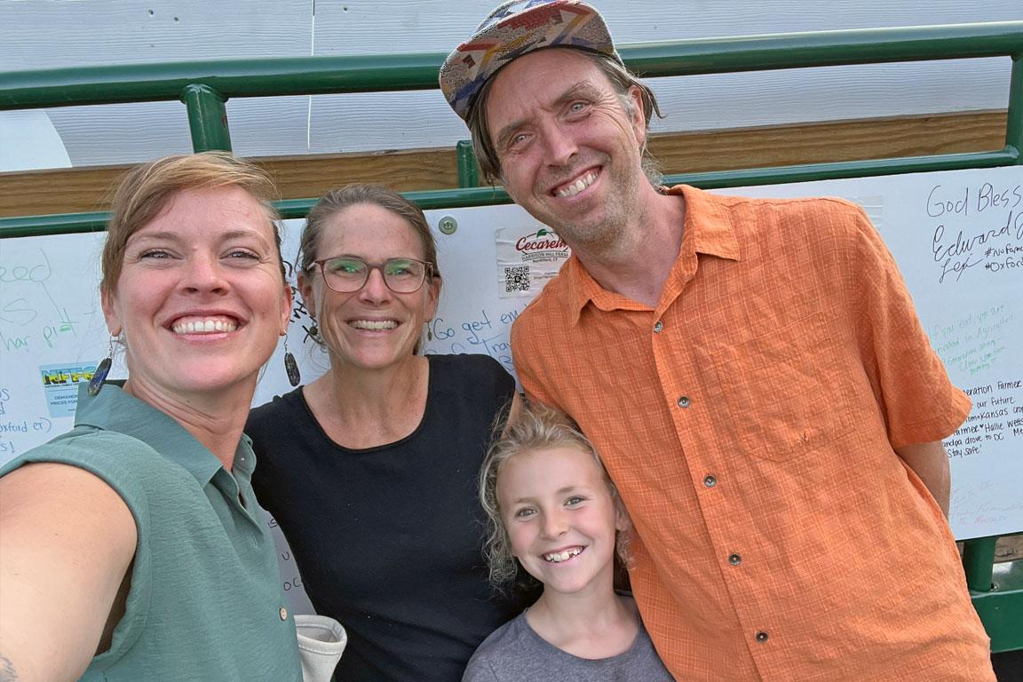 Maddie Kempner, NOFA VT Policy & Organizing Director pictured with NOFA-VT Board Member Becky Maden, her partner Scott Greene of Singing Cedars Farmstead, and their daughter, Ruth.