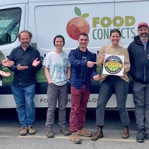 The team at Food Connects poses with their VOF organic certification logo in front of their delivery vehicle