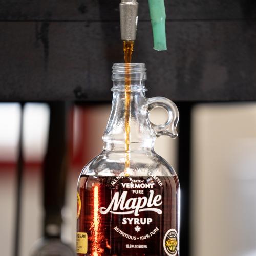 maple syrup being dispensed into a glass container